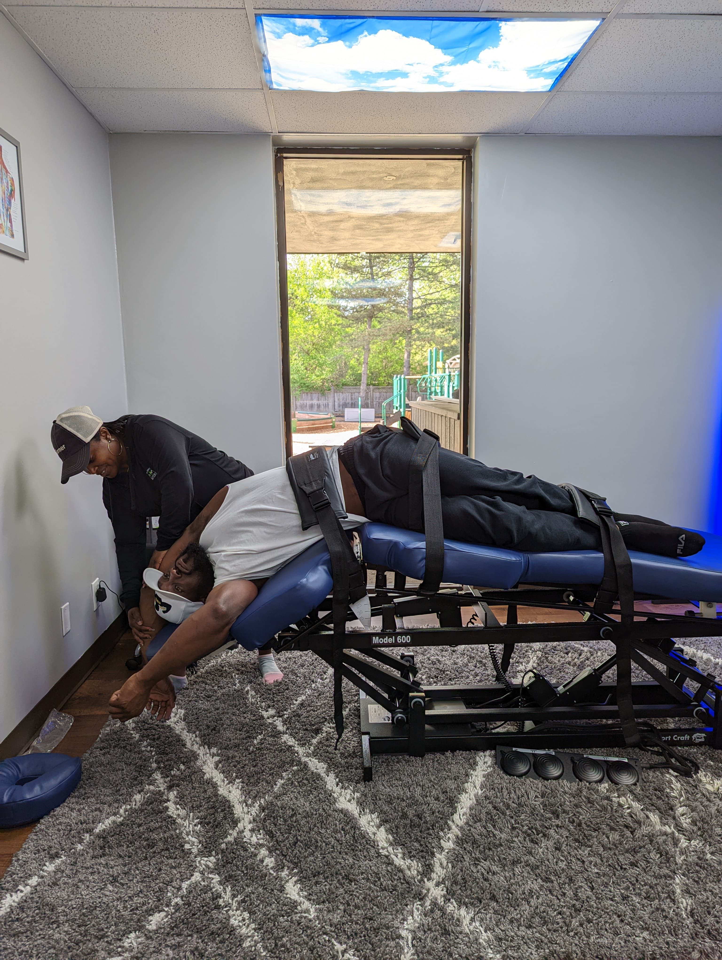 Practitioner performing back stretch therapy at Knot Me