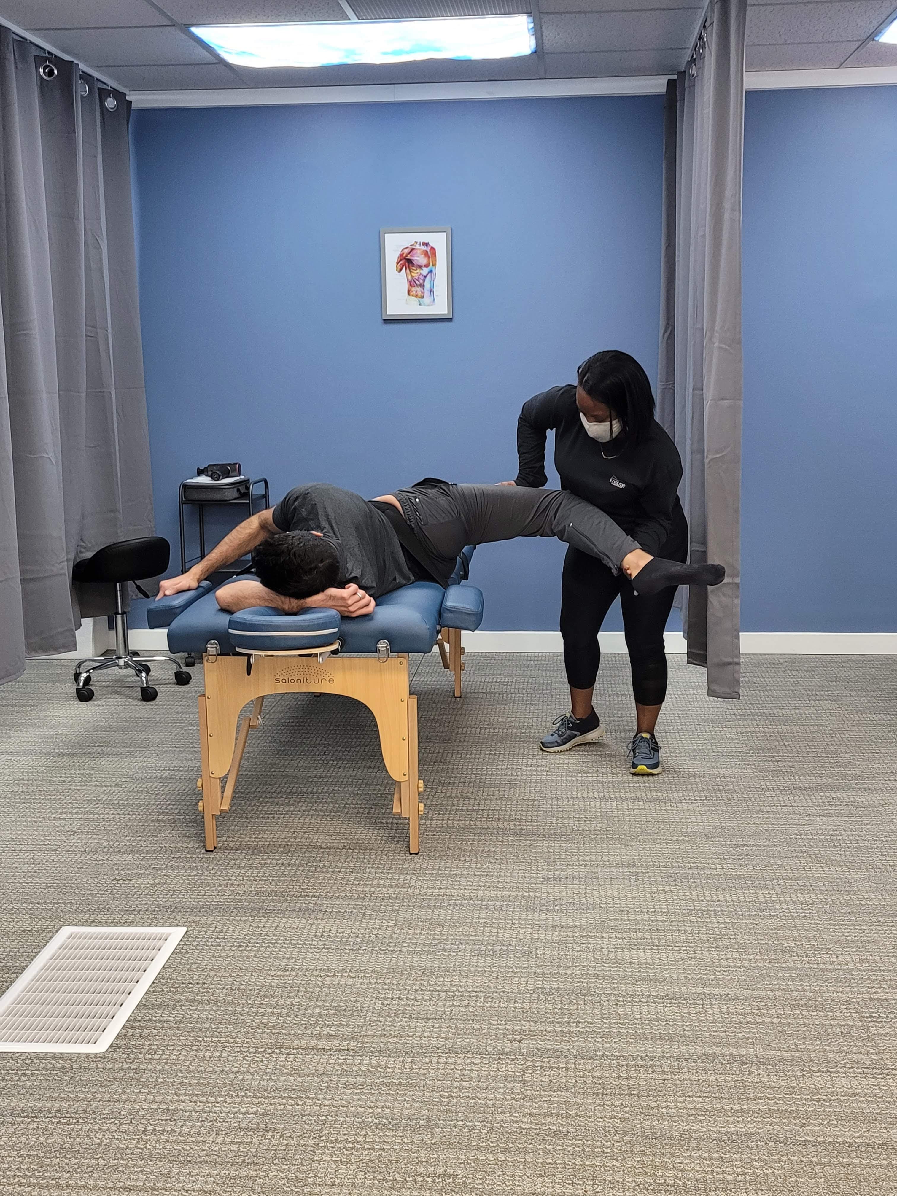 Practitioner performing hip stretch therapy at Knot Me