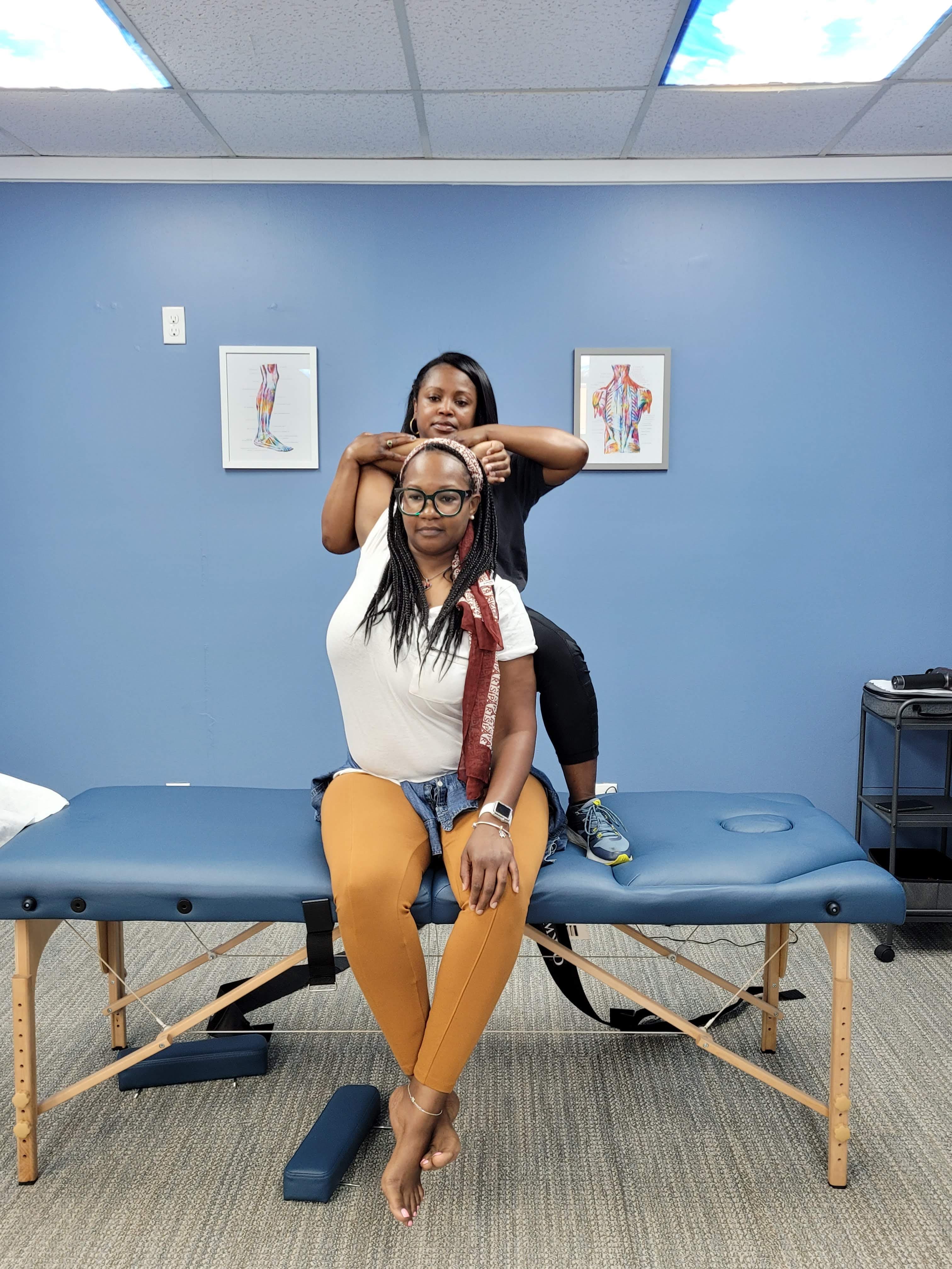 Practitioner performing neck and shoulder stretch therapy at Knot Me